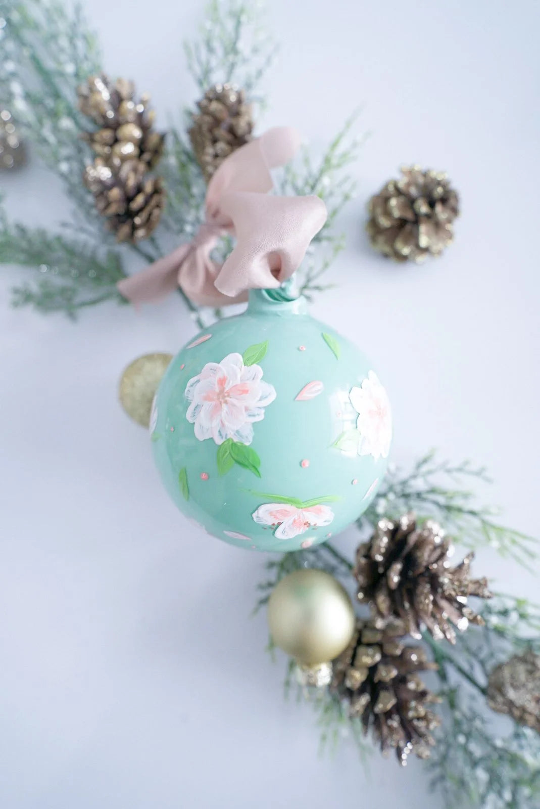 Hand painted peach and white florals on blue glass ornament