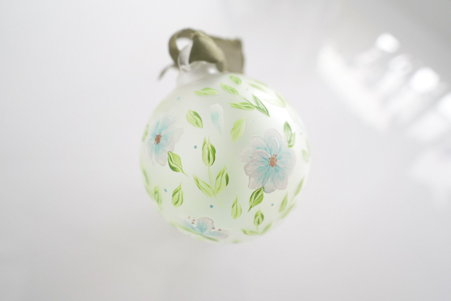 Hand painted light blue and white florals on frosted glass ornament