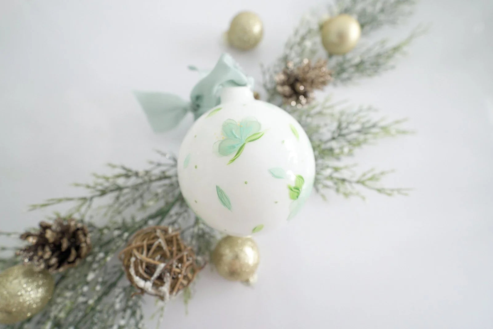 Hand painted light blue and white florals on white glass ornament